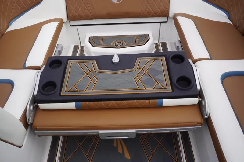 Slide: The Image of 2023 Tigé 24RZX boat interior with brown and white seating, geometric design, and cup holders. - 81