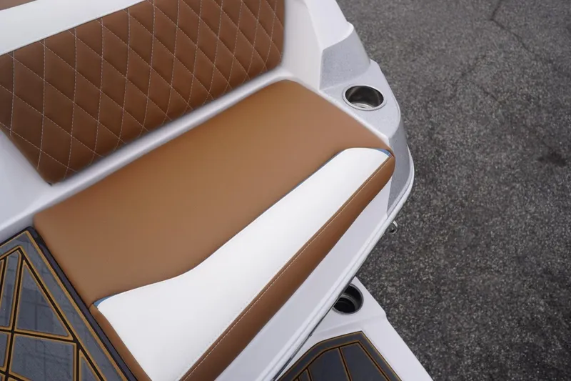 Slide: The Image of 2023 Tigé 24RZX boat seat with brown and white upholstery, diamond stitching, and cup holder. - 94