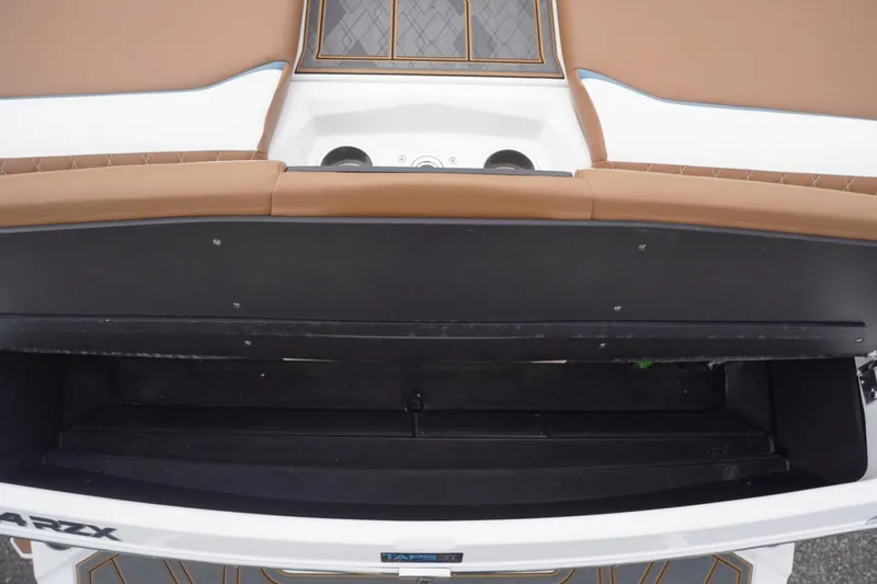 Slide: The Image of 2023 Tigé 24RZX boat interior with tan seating and storage compartment. - 96