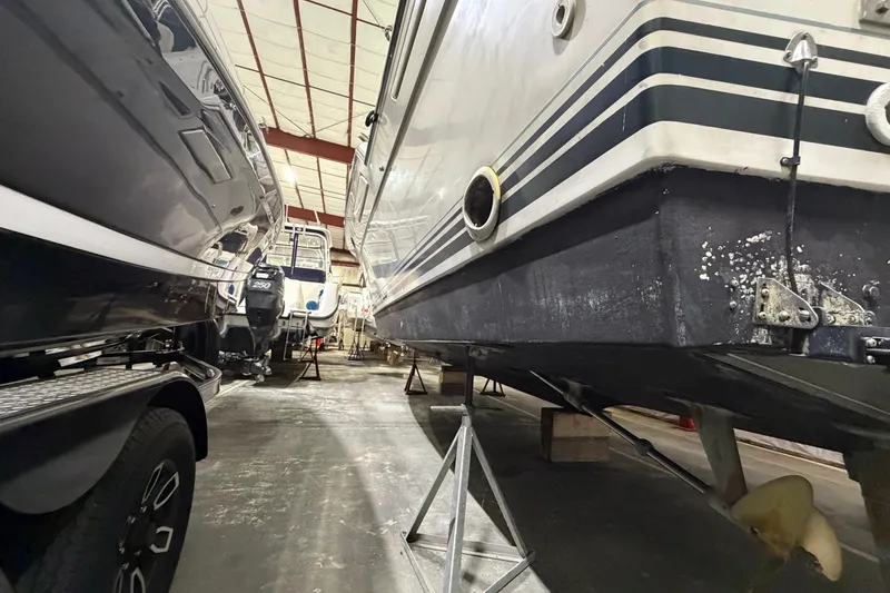 Slide: The Image of 1989 Tiara Yachts 3600 Open in storage, showcasing hull and propeller details. - 11