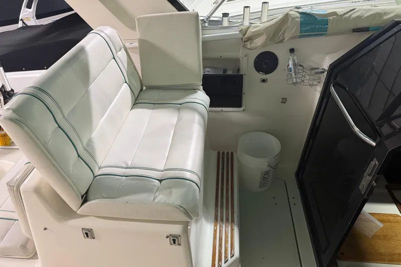 Slide: The Image of 1989 Tiara Yachts 3600 Open interior with white seating and cabin entrance. - 21