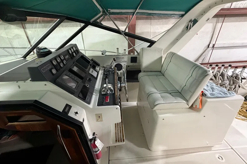Slide: The Image of 1989 Tiara Yachts 3600 Open helm with controls and cushioned seating. - 22