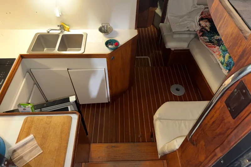 Slide: The Image of 1989 Tiara Yachts 3600 Open interior with kitchenette and seating area. - 31