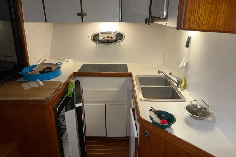 Slide: The Image of 1989 Tiara Yachts 3600 Open kitchen with dual sinks, stove, and storage. - 32