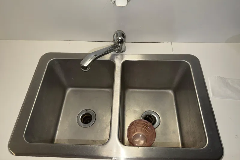 Slide: The Image of Stainless steel double sink with faucet, featuring a cup in the right basin. - 38