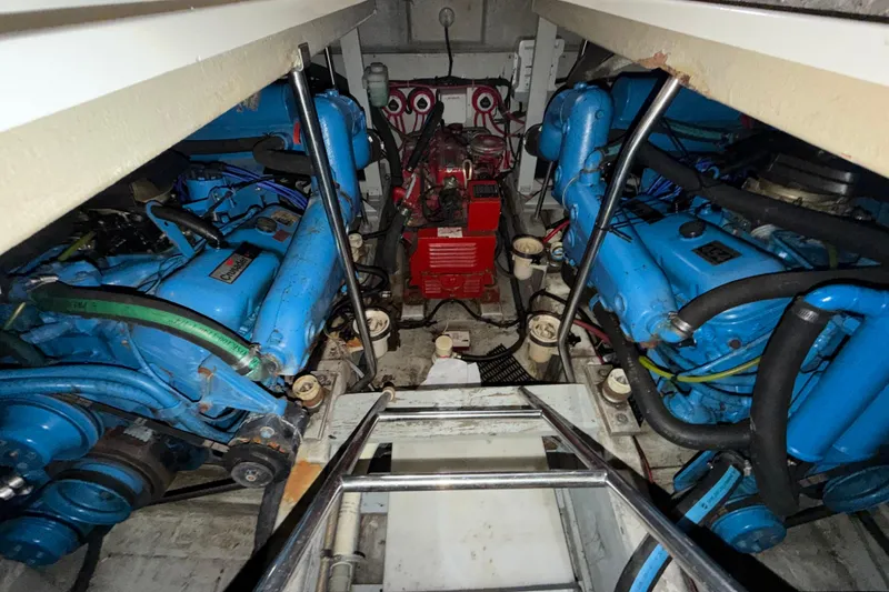 Slide: The Image of Engine room of 1989 Tiara Yachts 3600 Open with blue engines and red generator. - 48