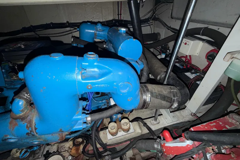 Slide: The Image of Engine room of 1989 Tiara Yachts 3600 Open, featuring blue engine components and wiring. - 52