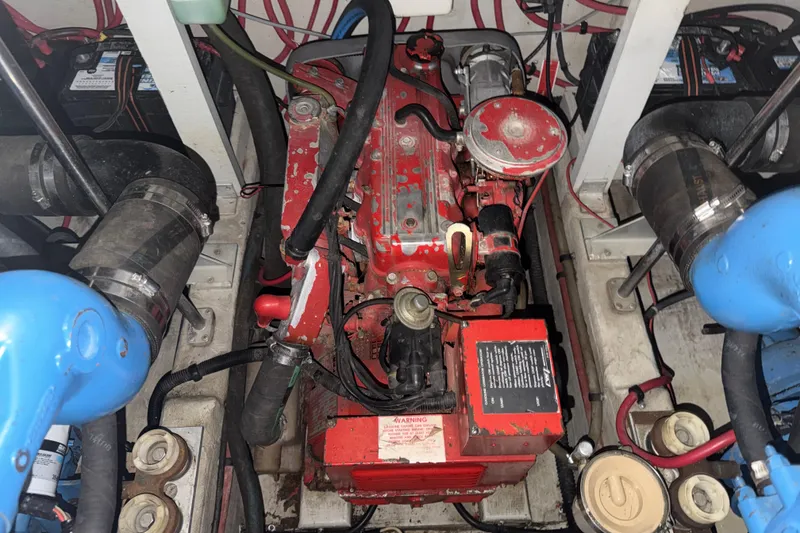 Slide: The Image of Engine compartment of a 1989 Tiara Yachts 3600 Open, featuring a red engine and surrounding components. - 55