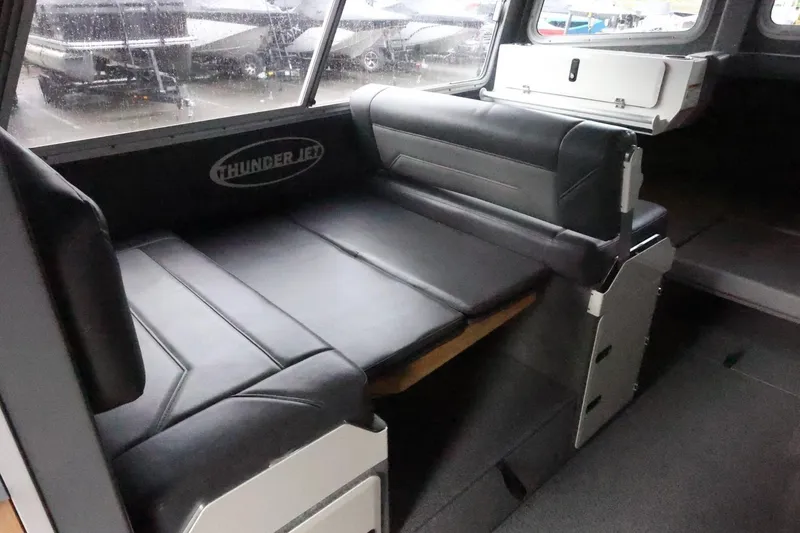 Slide: The Image of Interior of 2026 Thunder Jet 28 Pilot boat with black seating and storage. - 22