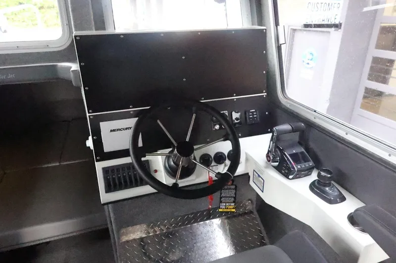 Slide: The Image of 2026 Thunder Jet 28 Pilot boat cockpit with steering wheel and control panel. - 24