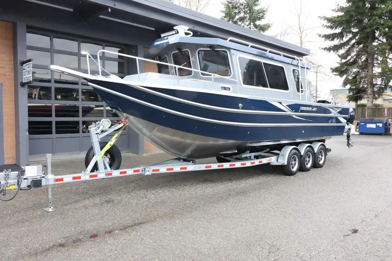 Slide: The Image of 2026 Thunder Jet 28 Pilot boat on trailer, parked outside a garage. - 3