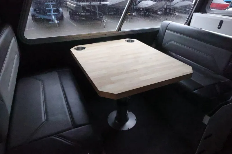 Slide: The Image of Interior of 2026 Thunder Jet 28 Pilot boat with wooden table and leather seating. - 36