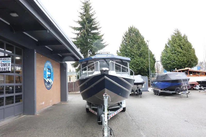 Slide: The Image of 2026 Thunder Jet 28 Pilot boat on trailer at dealership, surrounded by trees and other boats. - 4