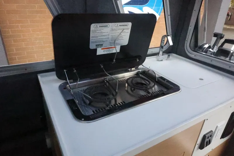 Slide: The Image of Interior of 2026 Thunder Jet 28 Pilot featuring a compact dual-burner stove. - 44