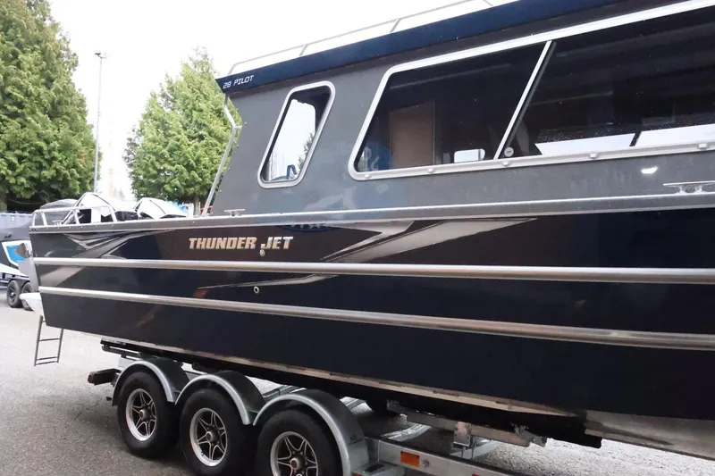 Slide: The Image of 2026 Thunder Jet 28 Pilot boat on trailer, sleek design, parked outdoors. - 6