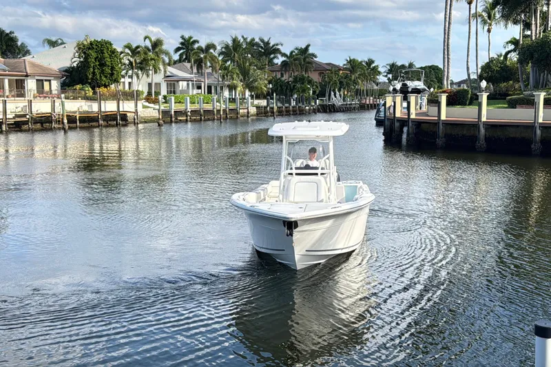 Slide: The Image of 2021 Sea Fox 268 Commander boat cruising in a scenic canal with palm trees. - 1
