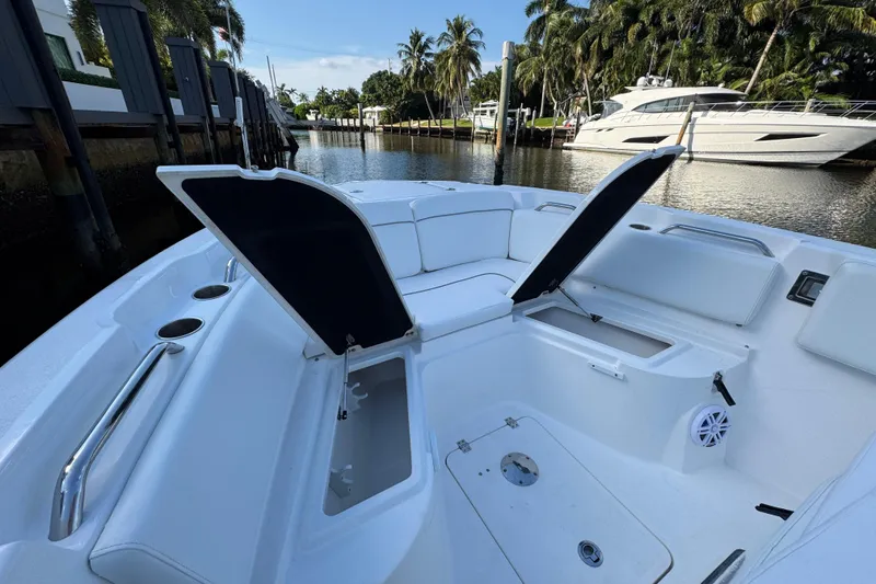 Slide: The Image of 2021 Sea Fox 268 Commander boat interior with open storage compartments, docked by a canal. - 10