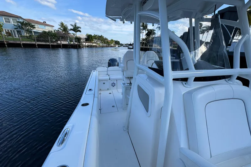 Slide: The Image of 2021 Sea Fox 268 Commander boat on a calm waterway, surrounded by waterfront homes. - 15