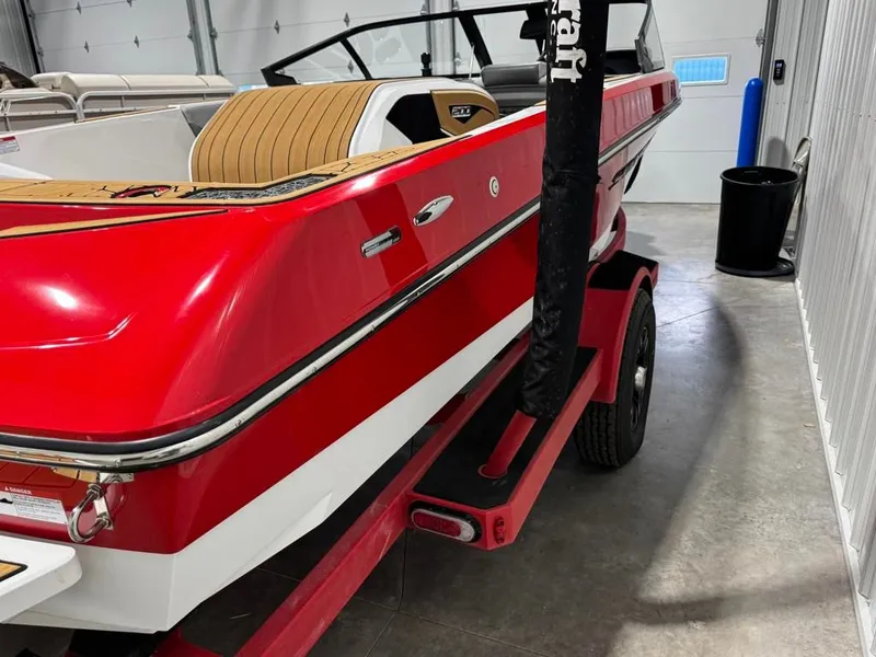 Slide: The Image of Red 2023 Nautique Ski Nautique 200 Open Bow boat in garage. - 20