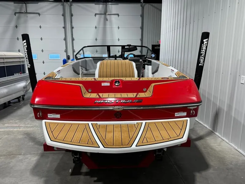 Slide: The Image of Red 2023 Nautique Ski Nautique 200 Open Bow boat in garage. - 21