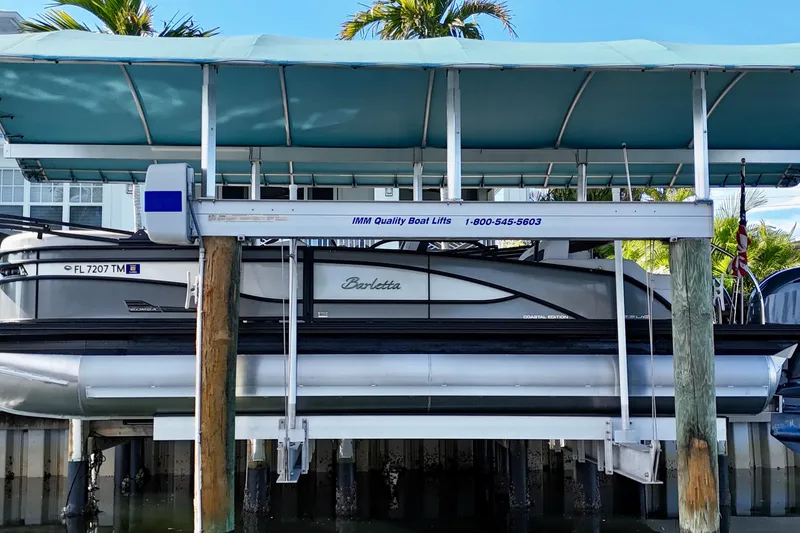 The Image of 2023 Barletta Corsa 23UC pontoon boat on lift under canopy. - 0