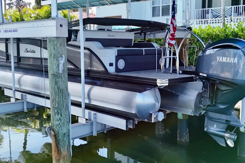 Slide: The Image of 2023 Barletta Corsa 23UC pontoon boat docked with Yamaha outboard motor. - 1