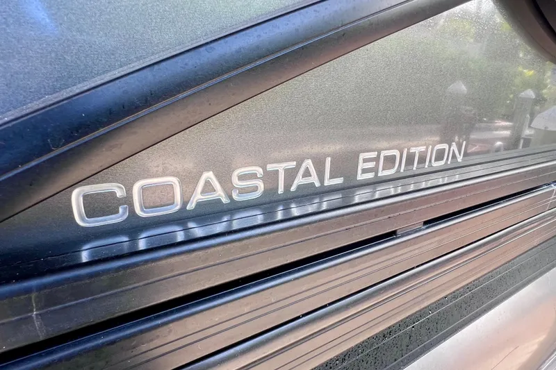 Slide: The Image of 2023 Barletta Corsa 23UC Coastal Edition logo on sleek black surface. - 11