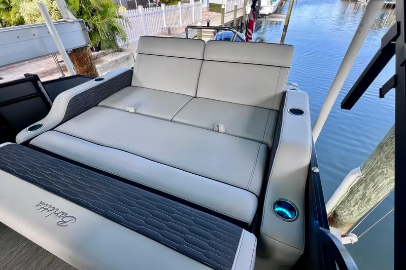 Slide: The Image of 2023 Barletta Corsa 23UC boat interior with luxurious seating and cup holders by the water. - 19
