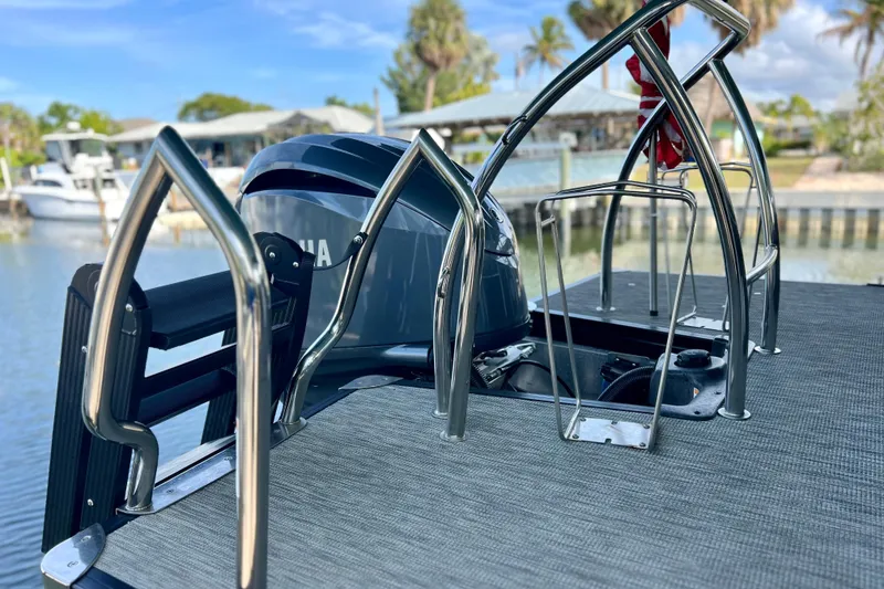 Slide: The Image of 2023 Barletta Corsa 23UC boat with Yamaha engine, docked near waterfront homes. - 21