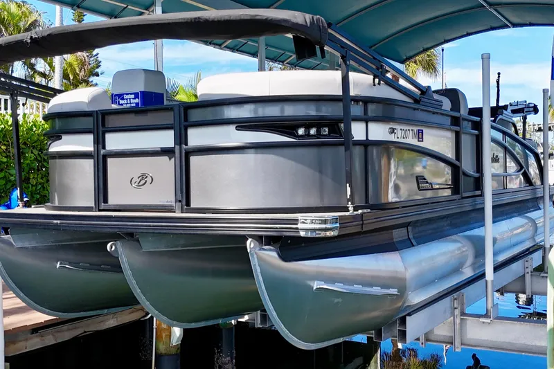 Slide: The Image of 2023 Barletta Corsa 23UC pontoon boat docked under a canopy. - 3