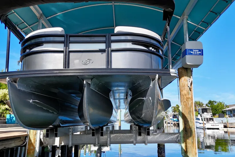 Slide: The Image of 2023 Barletta Corsa 23UC pontoon boat docked under a blue canopy. - 4