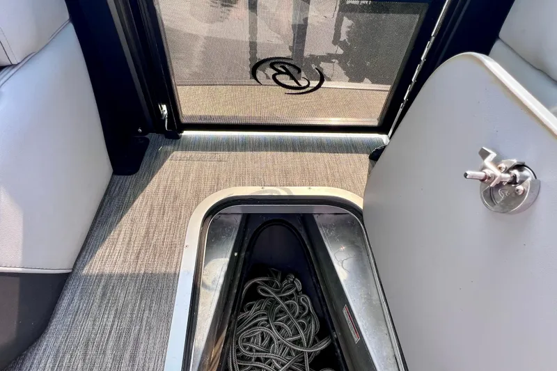 Slide: The Image of 2023 Barletta Corsa 23UC boat interior with storage compartment and rope. - 54