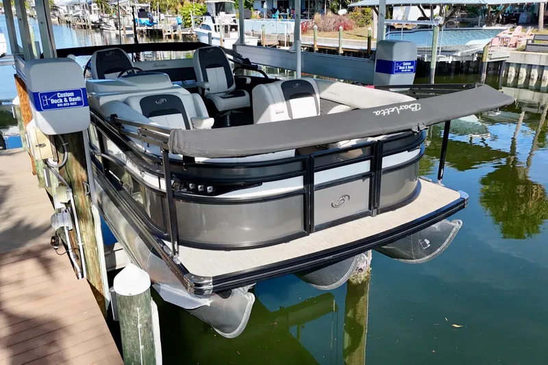 Slide: The Image of 2023 Barletta Corsa 23UC pontoon boat docked at a marina. - 6