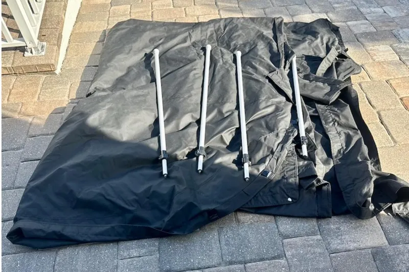 Slide: The Image of Black boat cover and poles for 2023 Barletta Corsa 23UC on paved surface. - 68