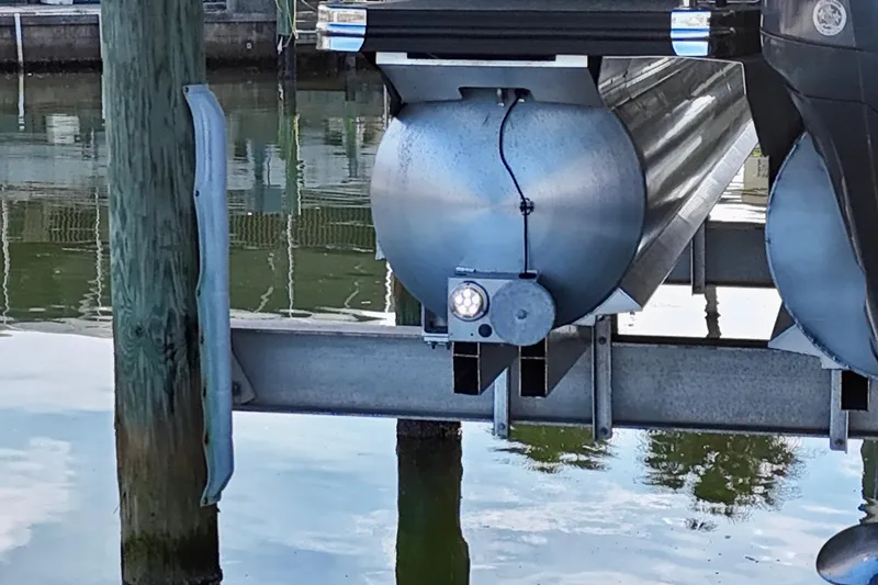 Slide: The Image of 2023 Barletta Corsa 23UC pontoon boat on a lift by the water. - 7