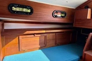 Slide: The Image of Interior of 2019 Com-Pac 23/IV sailboat with wooden finish and blue seating. - 13