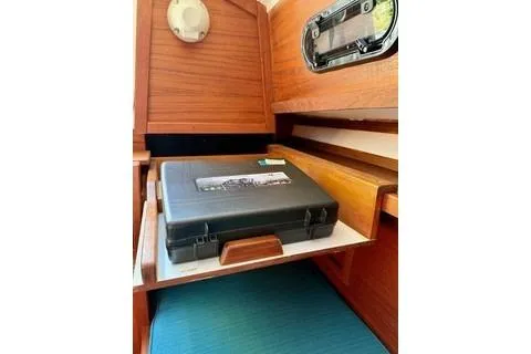 Slide: The Image of Interior of 2019 Com-Pac 23/IV sailboat with wooden cabinetry and storage compartment. - 15