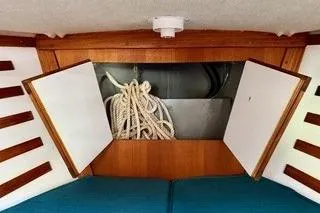 Slide: The Image of 2019 Com-Pac 23/IV sailboat interior with open storage and coiled rope. - 16