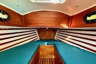 Slide: The Image of 2019 Com-Pac 23/IV sailboat interior with wood accents and teal paneling. - 17