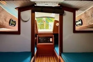 Slide: The Image of 2019 Com-Pac 23/IV sailboat interior with wood finish and blue cushions. - 19