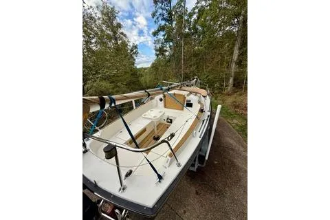 Slide: The Image of 2019 Com-Pac 23/IV sailboat on trailer, surrounded by lush greenery. - 6