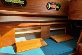 Slide: The Image of Interior of 2019 Com-Pac 23/IV sailboat with wooden cabinetry and blue cushions. - 8