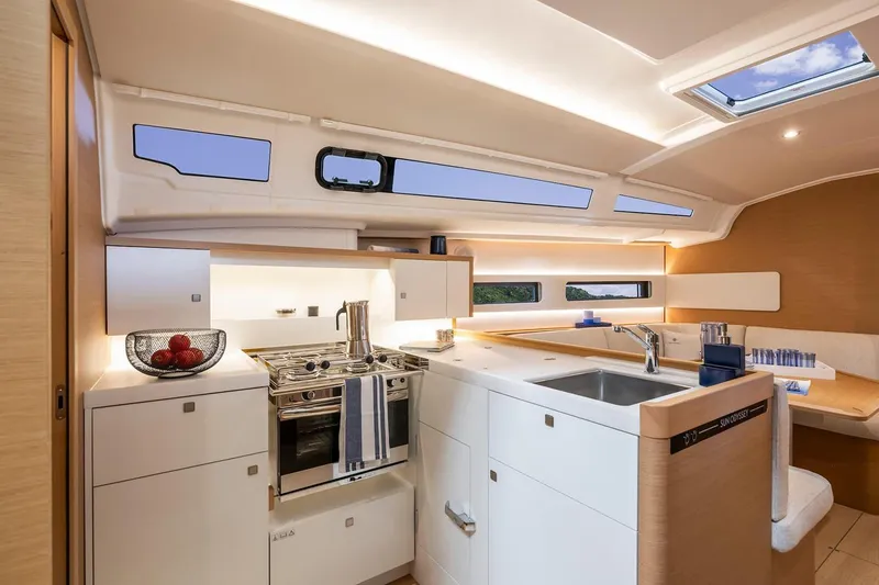 Slide: The Image of Manufacturer Provided Image: Modern kitchen interior of 2025 Jeanneau Sun Odyssey 415 yacht, featuring sleek design and amenities. - 5