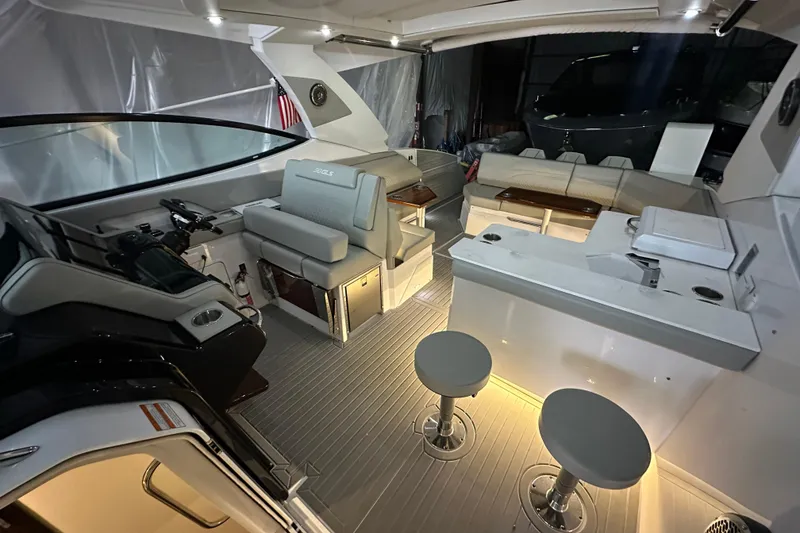 Slide: The Image of 2024 Cruisers Yachts 38 GLS OB interior with seating, helm, and bar stools. - 11
