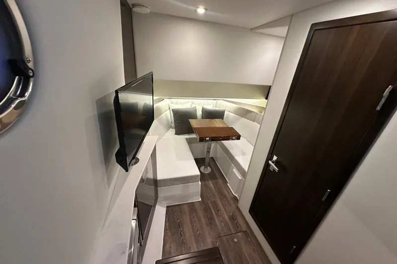 Slide: The Image of 2024 Cruisers Yachts 38 GLS OB interior with modern seating, table, and TV. - 12