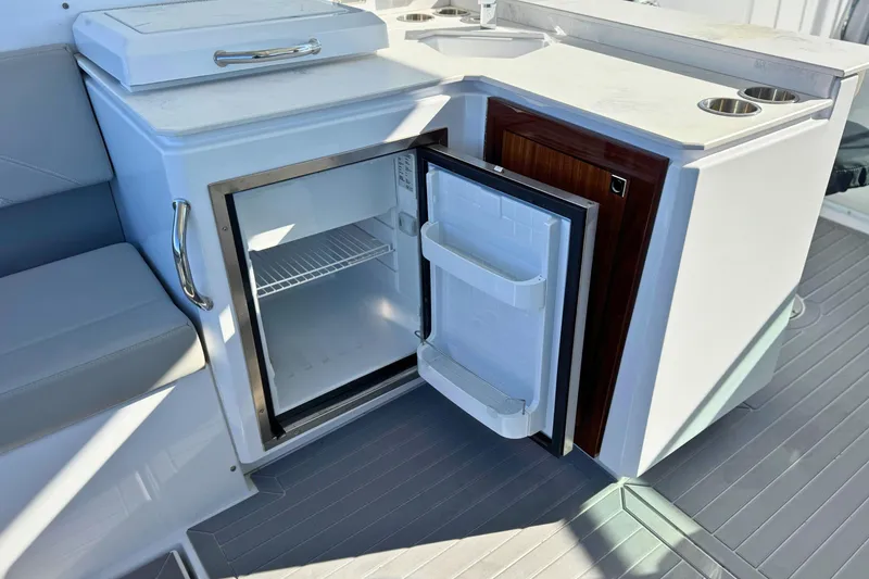 Slide: The Image of 2024 Cruisers Yachts 38 GLS OB boat interior with open mini fridge and seating area. - 22