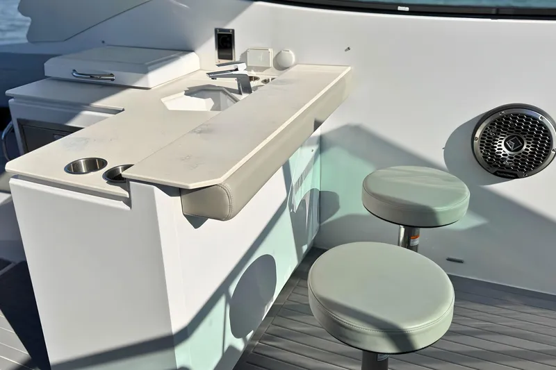 Slide: The Image of 2024 Cruisers Yachts 38 GLS OB interior with bar stools and speaker. - 30