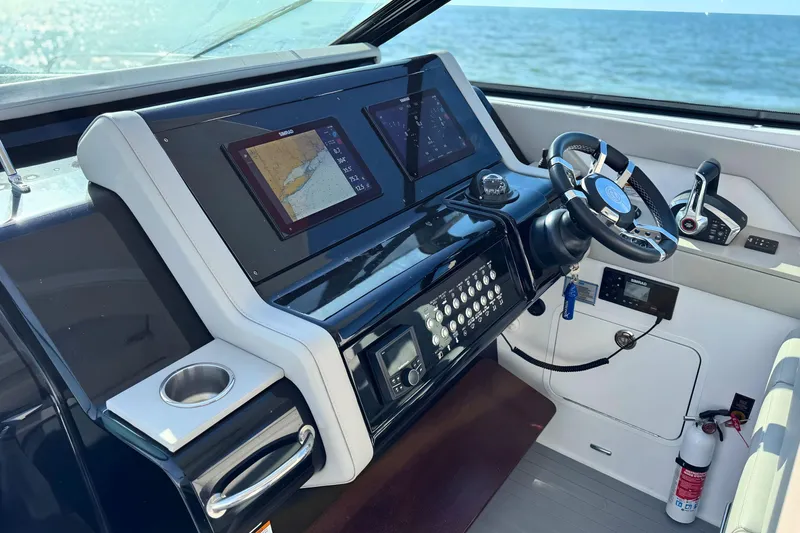 Slide: The Image of 2024 Cruisers Yachts 38 GLS OB helm with navigation screens and steering wheel. - 32
