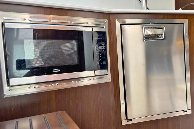 Slide: The Image of Microwave and fridge in 2024 Cruisers Yachts 38 GLS OB galley. - 47