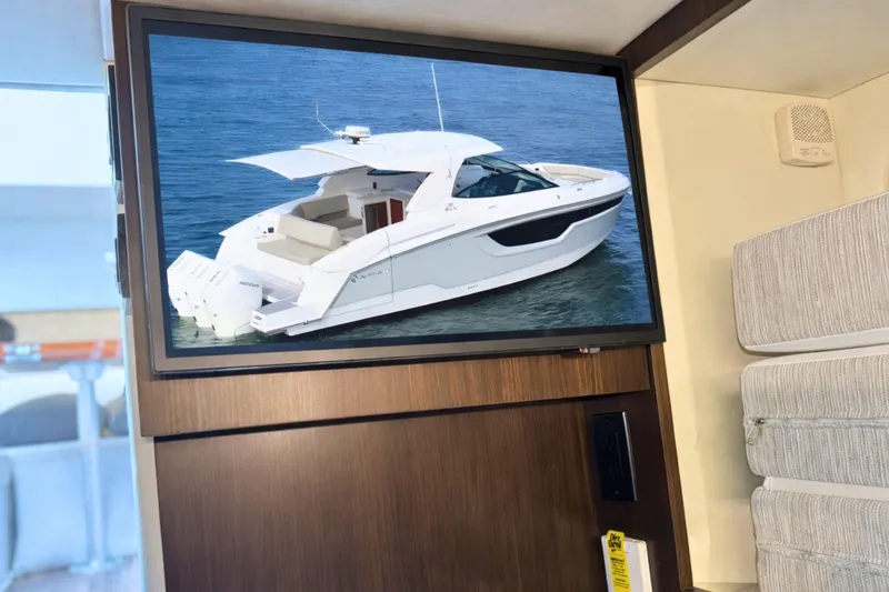 Slide: The Image of 2024 Cruisers Yachts 38 GLS OB displayed on a screen in a modern interior. - 56